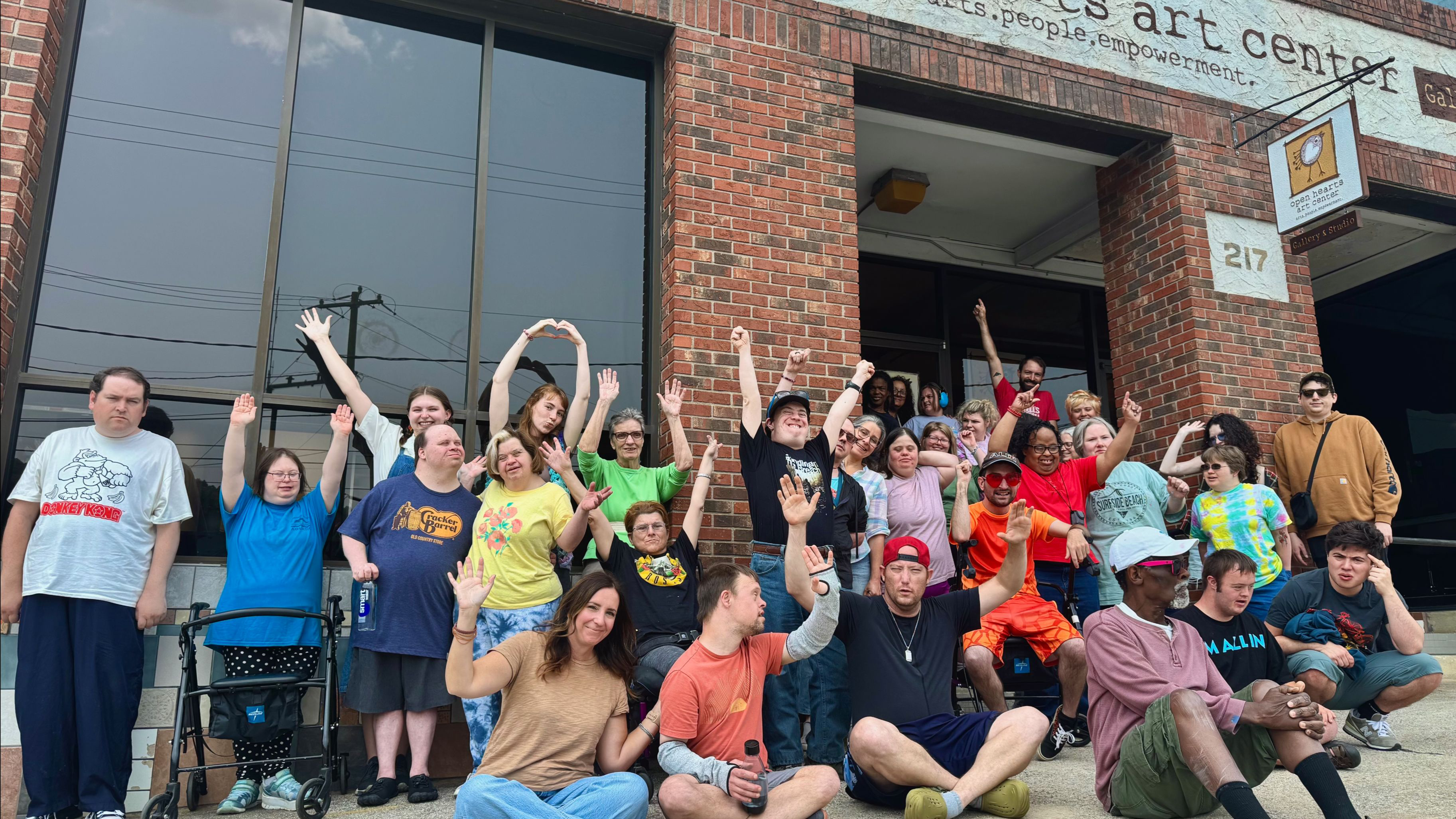 artists cheers in front of Open Hearts Art Center