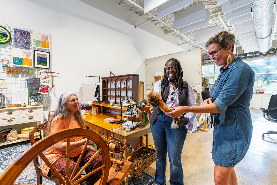 Two women look at a spinning wheel