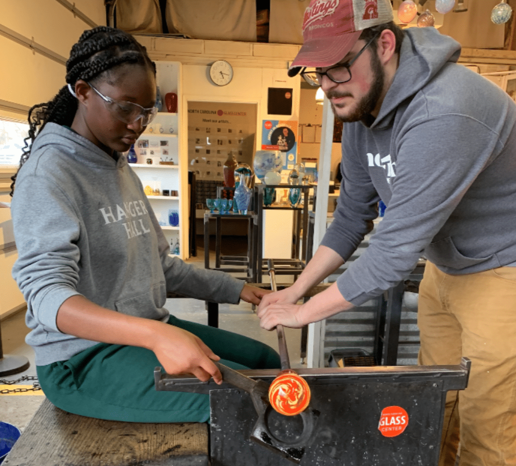 A student working in a glass class at NC Glass