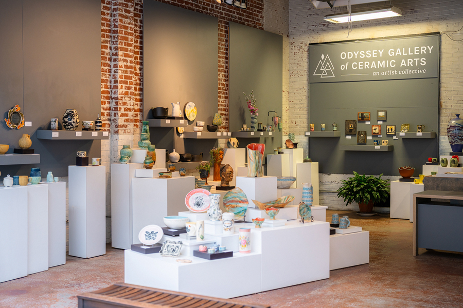 a ceramic gallery with pottery on white shelves